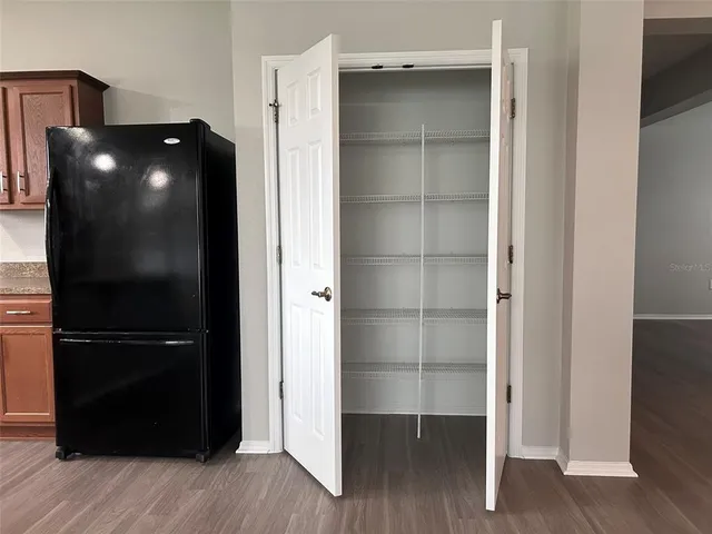 a view of walk in closet with wooden floor