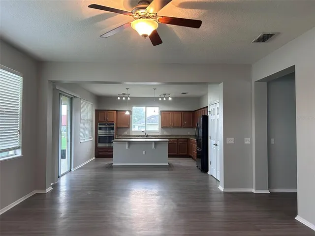 a kitchen with a refrigerator and wooden floor