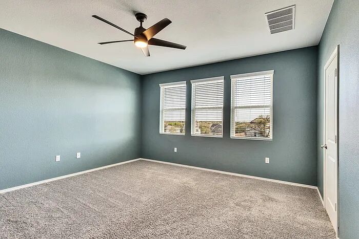 10403 Bramble Berry Drive Austin, TX 78748 - Photo 9 of 21 an empty room with windows and ceiling fan