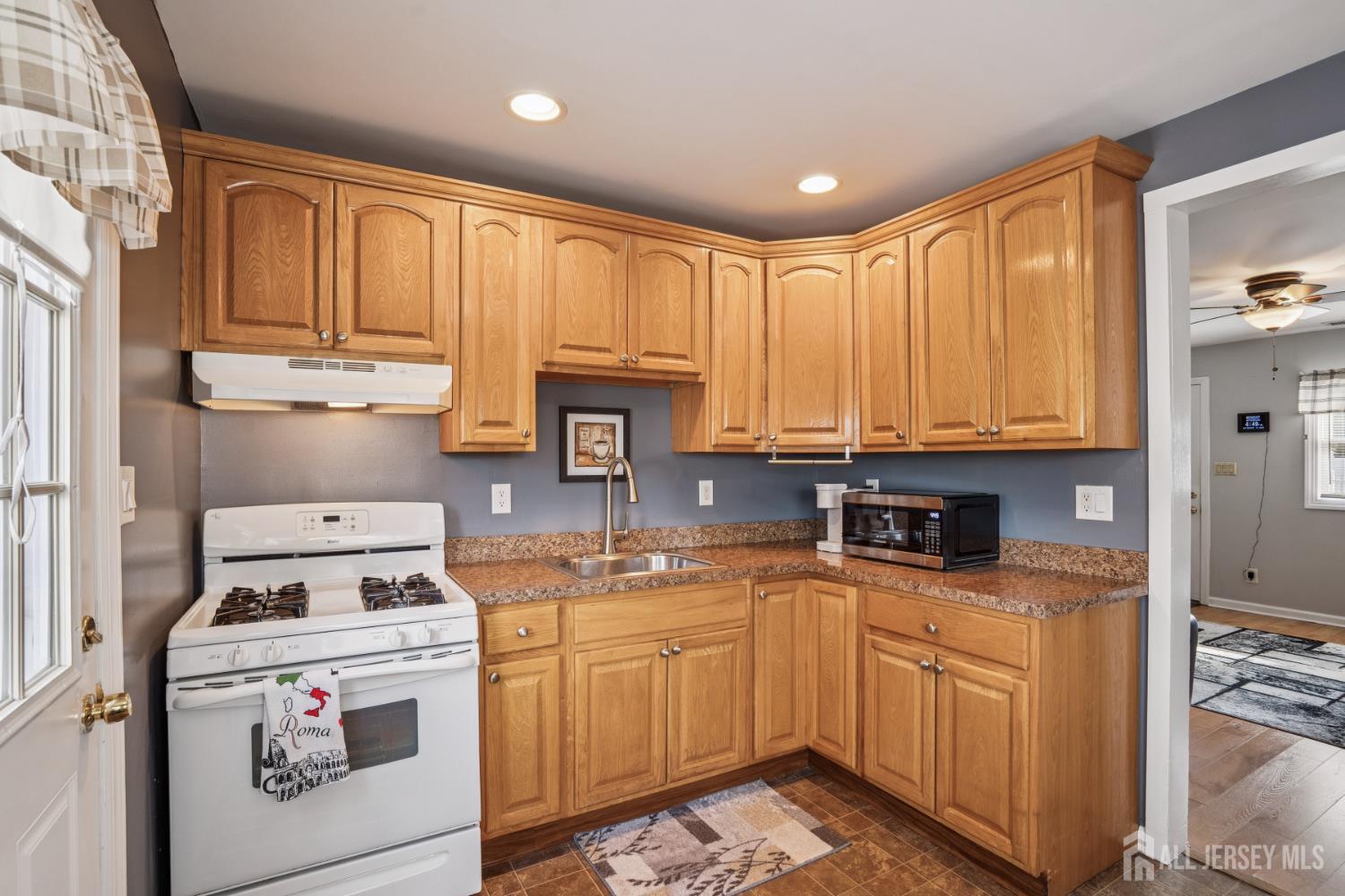 12 Brookville Road Edison, NJ 08817 - Photo 5 of 25 a kitchen with kitchen island granite countertop a sink a stove and cabinets