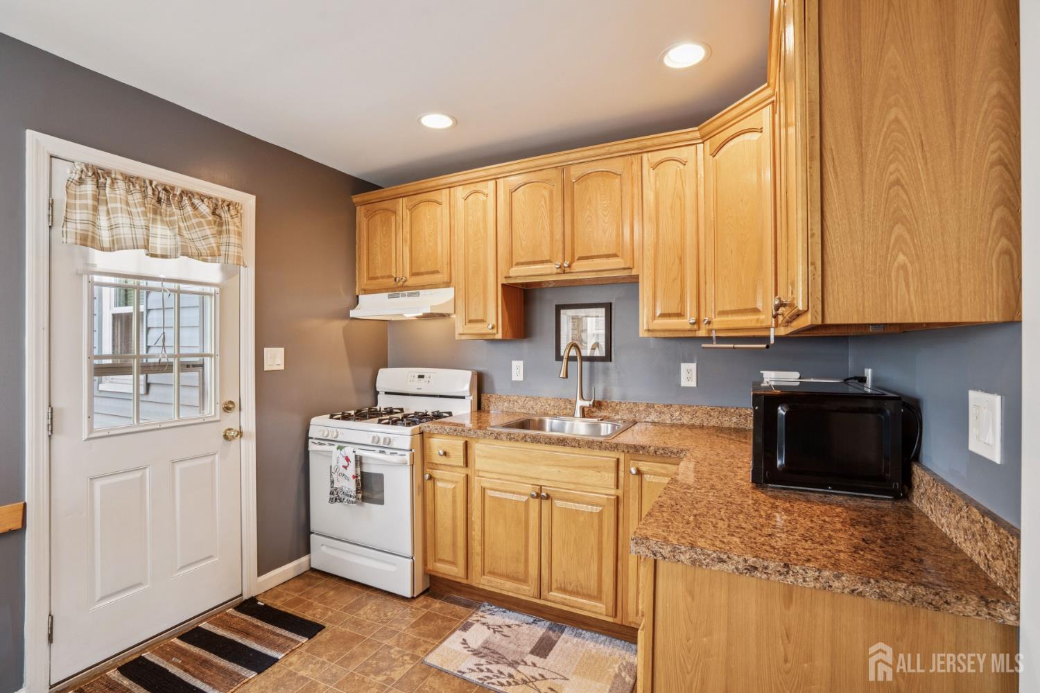 12 Brookville Road Edison, NJ 08817 - Photo 6 of 25 a kitchen with a stove a sink and a microwave