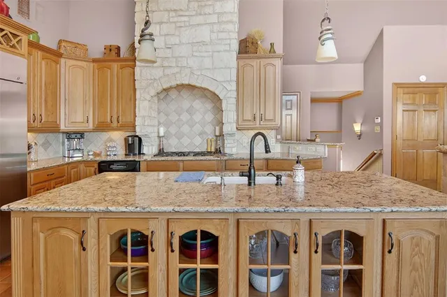 a kitchen with stainless steel appliances granite countertop a sink stove and cabinets