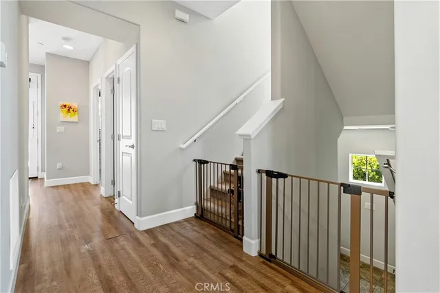 a view of a hallway with wooden floor and staircase