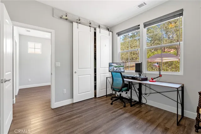 a view of a workspace with furniture and a window