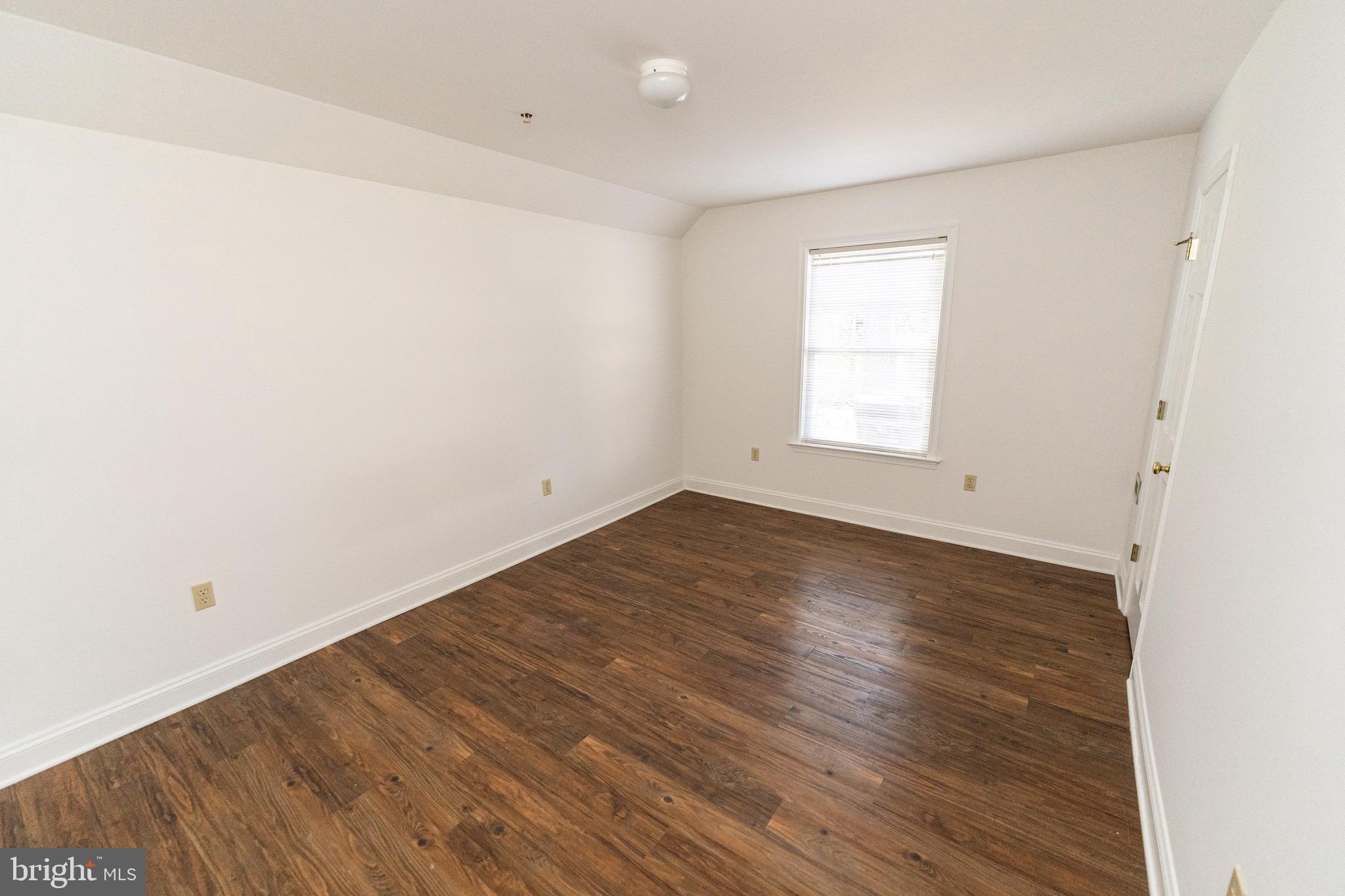 804 Travers Street, Unit 2 Cambridge, MD 21613 - Photo 16 of 26 an empty room with wooden floor and window