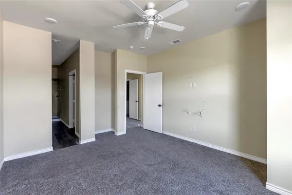 a view of an empty room with a ceiling fan