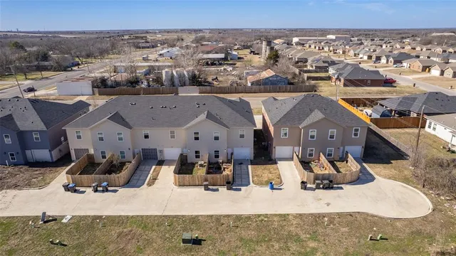 an aerial view of residential houses with outdoor space and parking