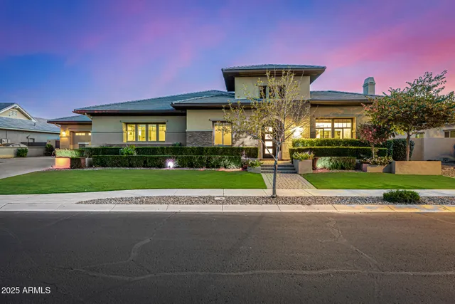 a front view of a house with a yard and potted plants