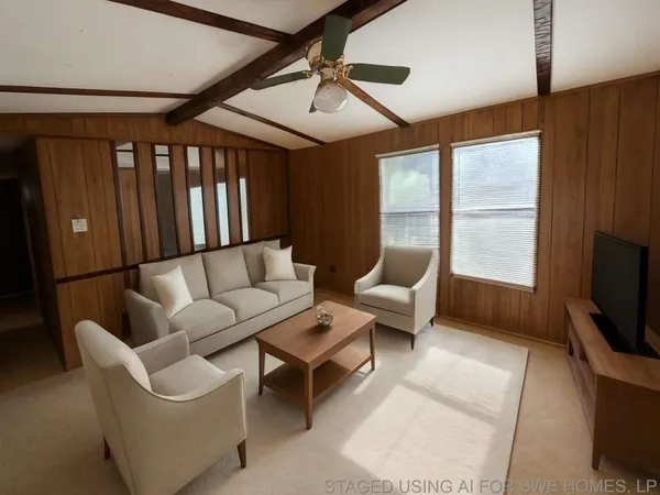 a living room with furniture a flat screen tv and a window