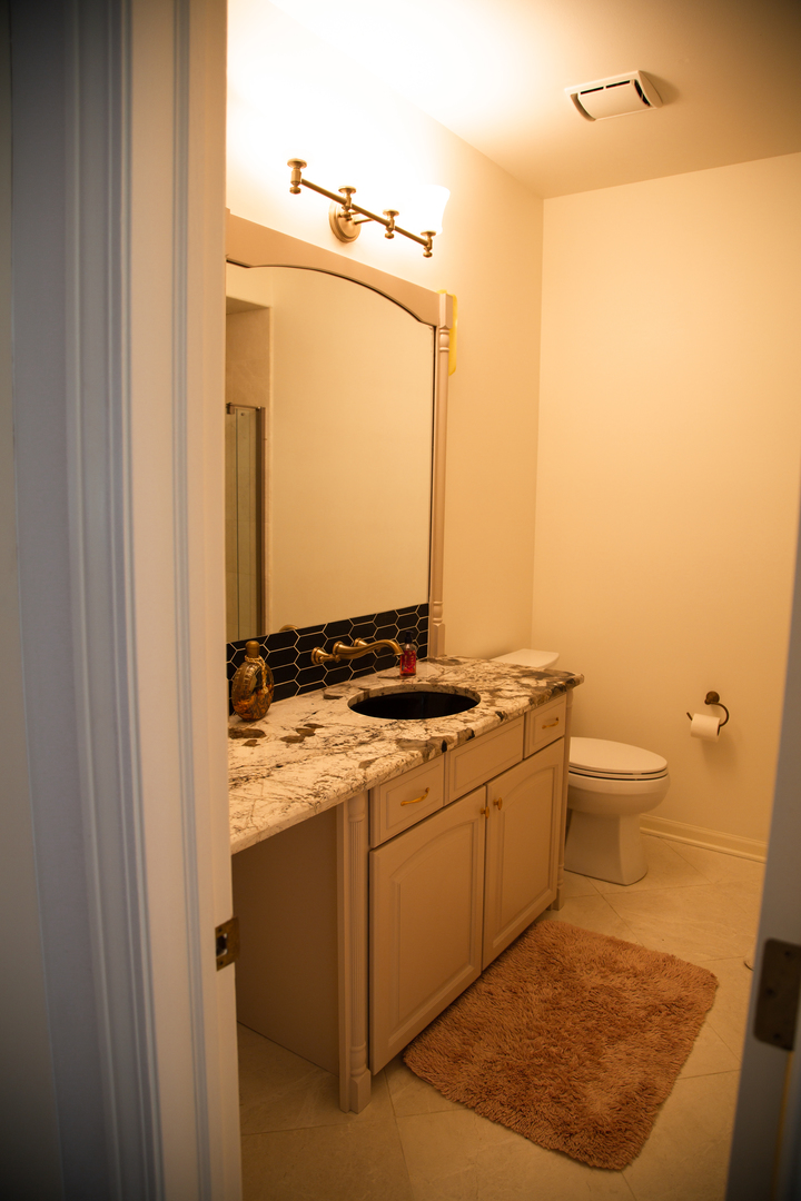 28W130 Roosevelt Road Winfield, IL 60190 - Photo 42 of 54 a bathroom with a granite countertop sink and a mirror