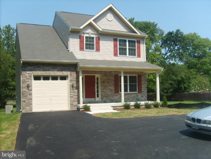 7720 North Point Road Edgemere, MD 21219 - Photo 1 of 22 a front view of a house with a yard and garage