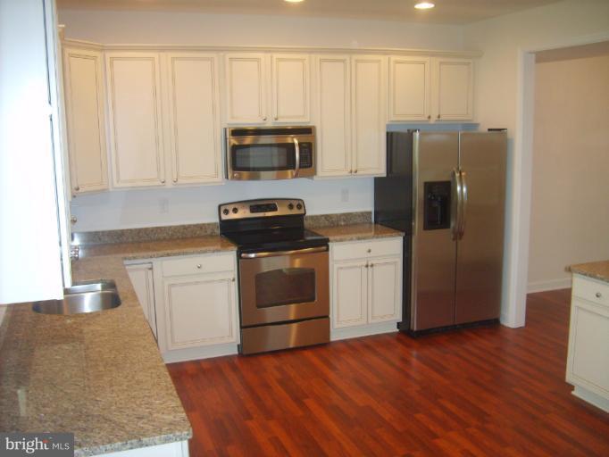 7720 North Point Road Edgemere, MD 21219 - Photo 17 of 22 a kitchen with stainless steel appliances a refrigerator stove and microwave