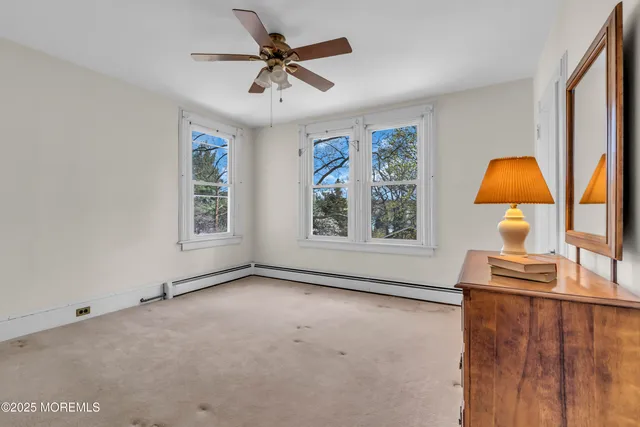 a front view of a house with a garden and trees