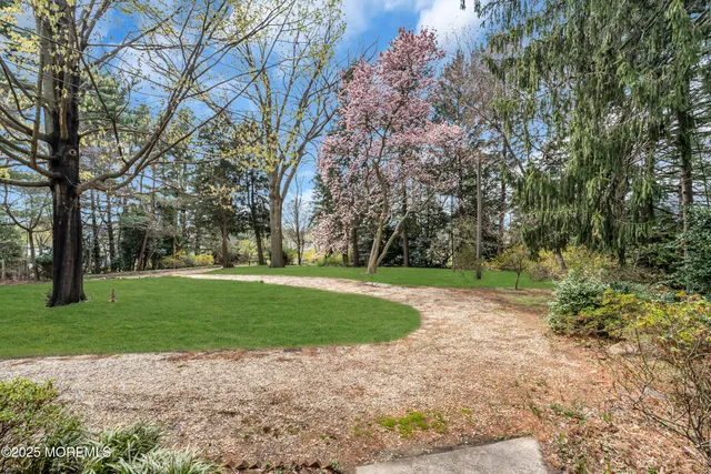 a backyard of a house with lots of green space and fountain