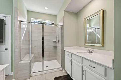 a bathroom with a shower sink and mirror