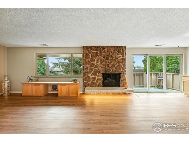 a view of empty room with wooden floor and fireplace