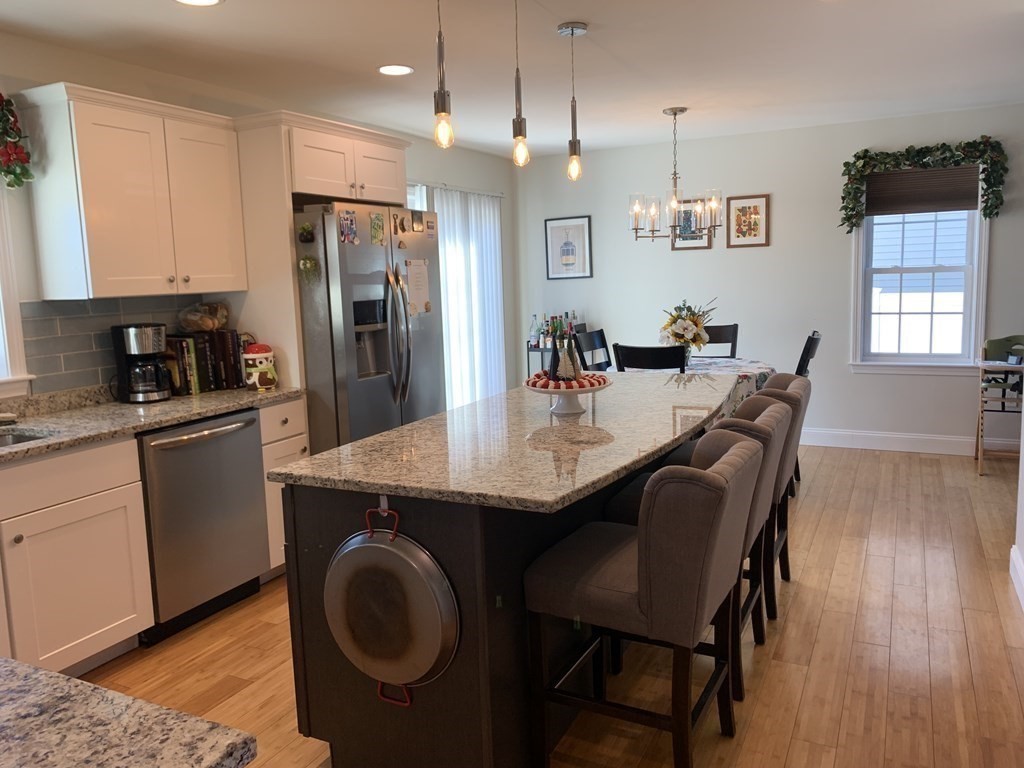 418 Smith Street Fall River, MA 02721 - Photo 11 of 37 a kitchen with a table chairs refrigerator and microwave