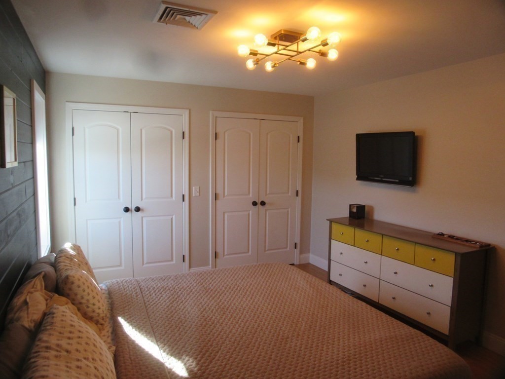 418 Smith Street Fall River, MA 02721 - Photo 23 of 37 a bedroom with a bed and a flat tv screen on dresser