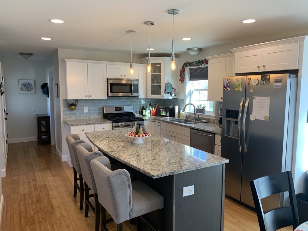 418 Smith Street Fall River, MA 02721 - Photo 8 of 37 a kitchen with stainless steel appliances granite countertop a refrigerator a stove a sink a dining table and chairs