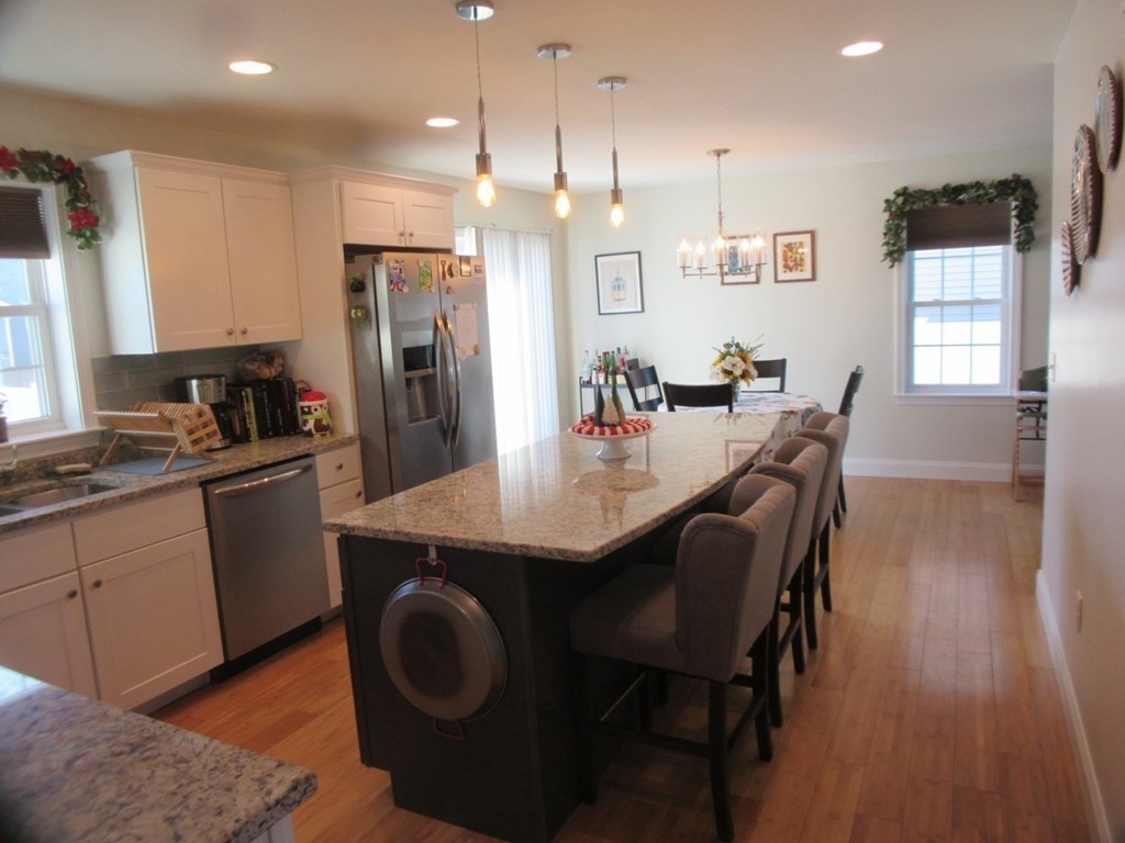 418 Smith Street Fall River, MA 02721 - Photo 10 of 37 a kitchen with kitchen island a dining table chairs and a refrigerator
