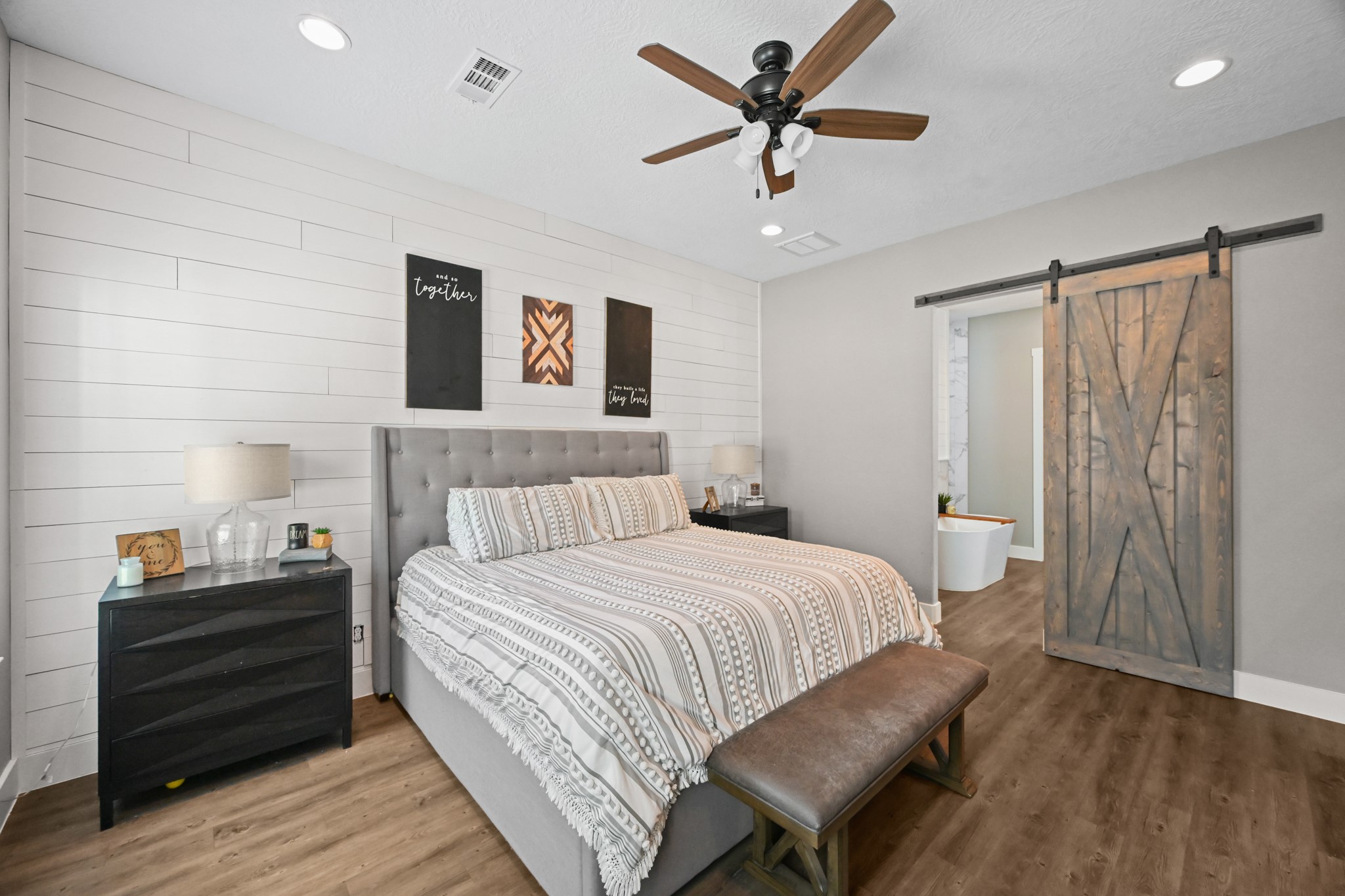 16912 Wagon Wheel Road Stagecoach, TX 77355 - Photo 23 of 39 a bedroom with a bed and a chandelier