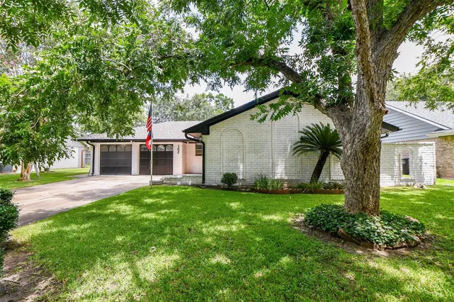 a front view of a house with a garden and yard