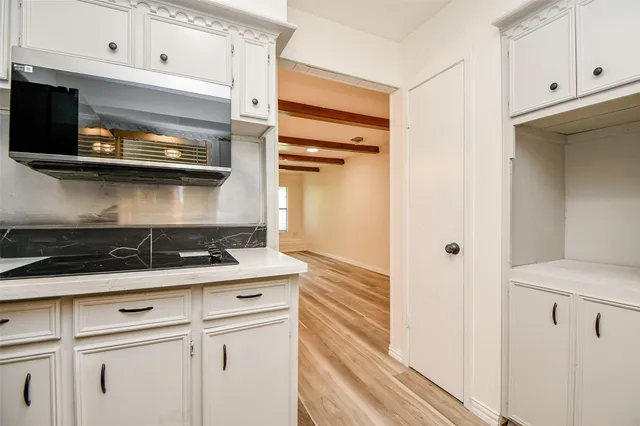 a kitchen with white cabinets and appliances