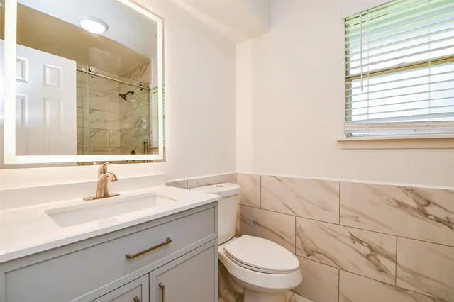 a bathroom with a sink toilet and shower