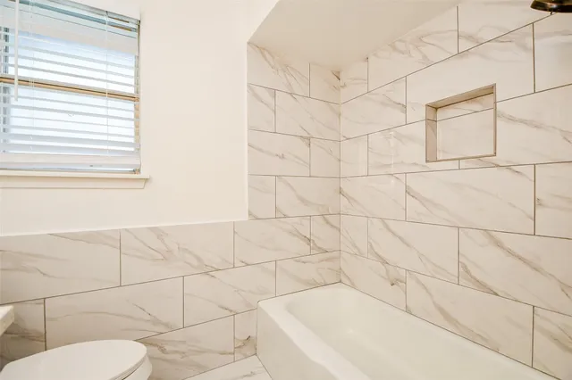 a bathroom with a bathtub and toilet
