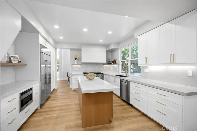 a large kitchen with stainless steel appliances lots of counter space and a sink