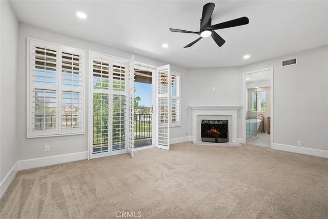 a view of a livingroom with a fireplace and a ceiling fan