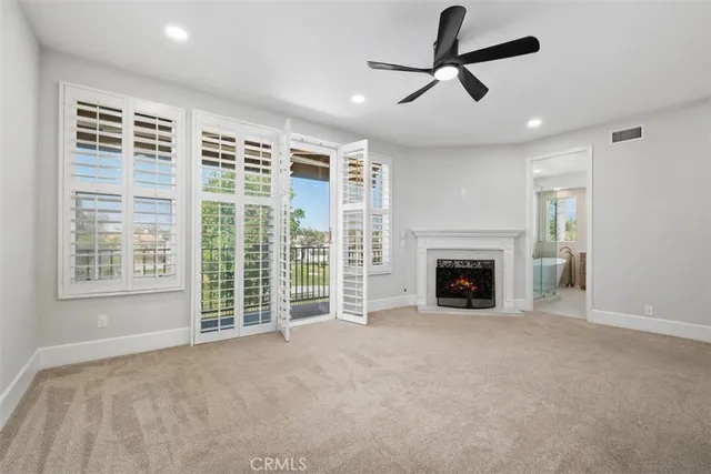 a view of a livingroom with a fireplace and a ceiling fan
