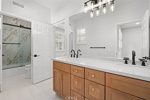 a bathroom with a double vanity sink mirror and shower