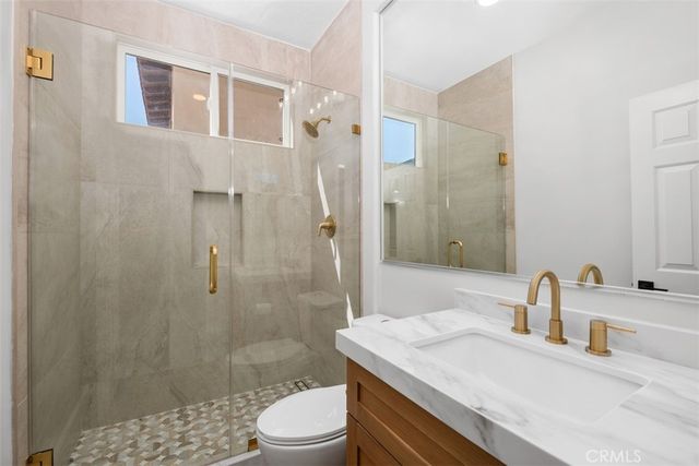 a bathroom with a sink a toilet and shower