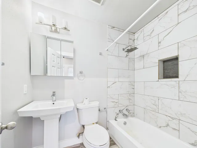 a bathroom with a sink a toilet and shower