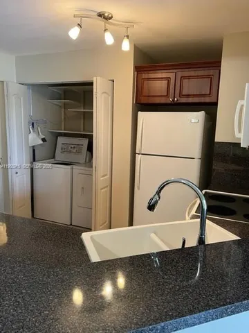 a kitchen with a refrigerator and a sink