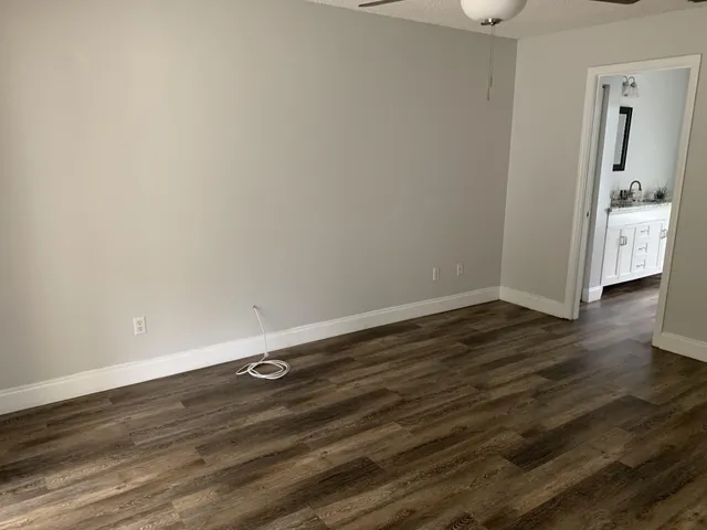 an empty room with wooden floor and mirror