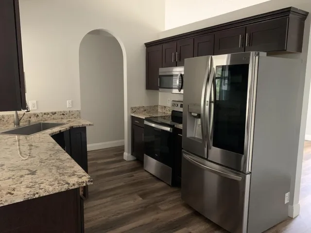 a kitchen with stainless steel appliances granite countertop a refrigerator and a stove