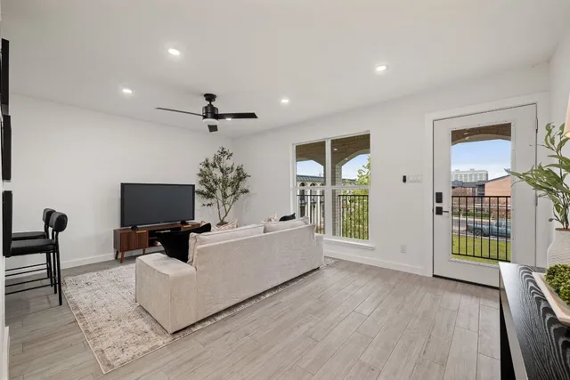 a living room with furniture a chandelier and a flat screen tv