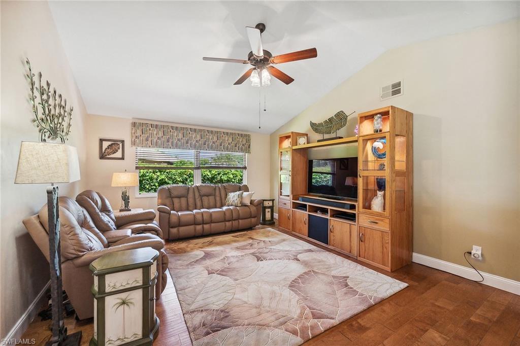 900 Hidden Harbour Drive Naples, FL 34109 - Photo 11 of 32 a living room with furniture a flat screen tv and a fireplace