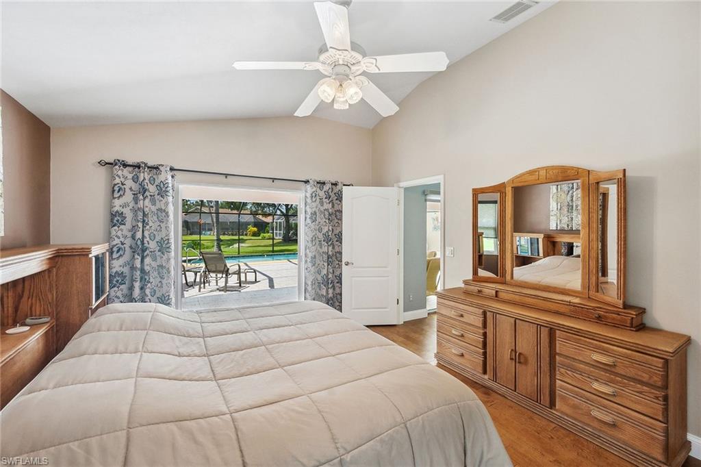 900 Hidden Harbour Drive Naples, FL 34109 - Photo 14 of 32 a bedroom with a large bed and a large mirror on a dresser