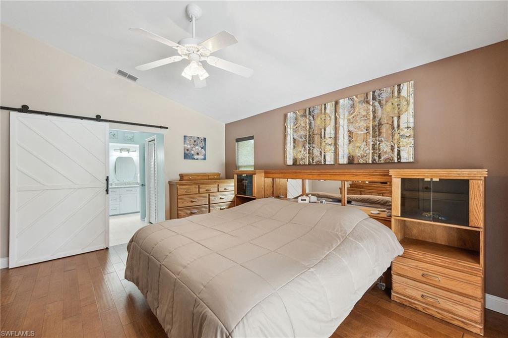 900 Hidden Harbour Drive Naples, FL 34109 - Photo 15 of 32 a bedroom with a large bed and a chandelier fan