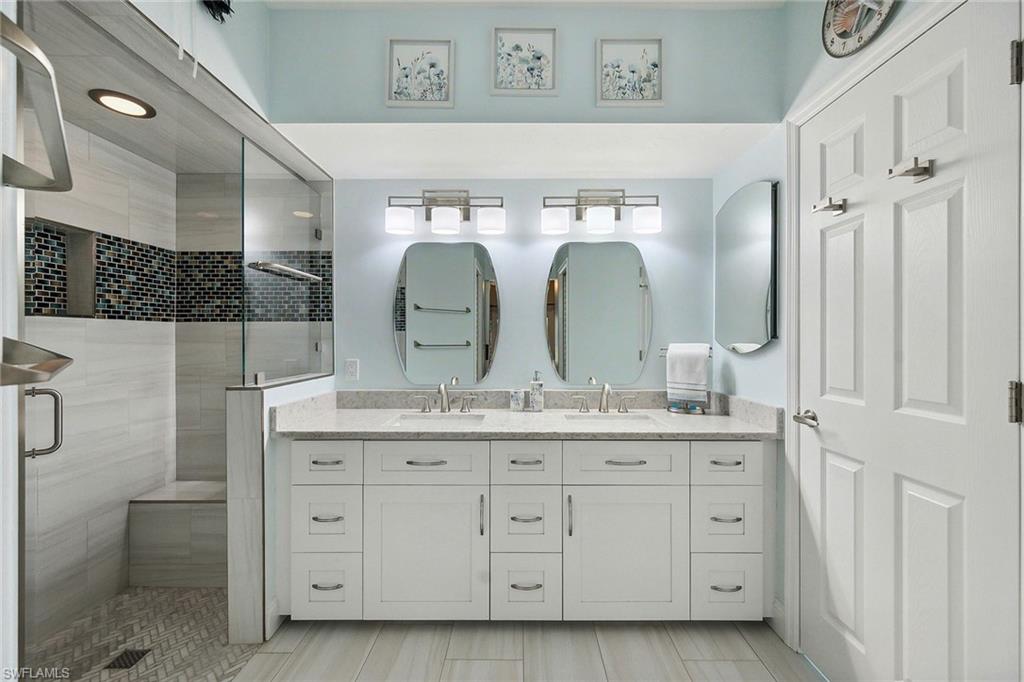 900 Hidden Harbour Drive Naples, FL 34109 - Photo 16 of 32 a bathroom with a double vanity sink and a mirror