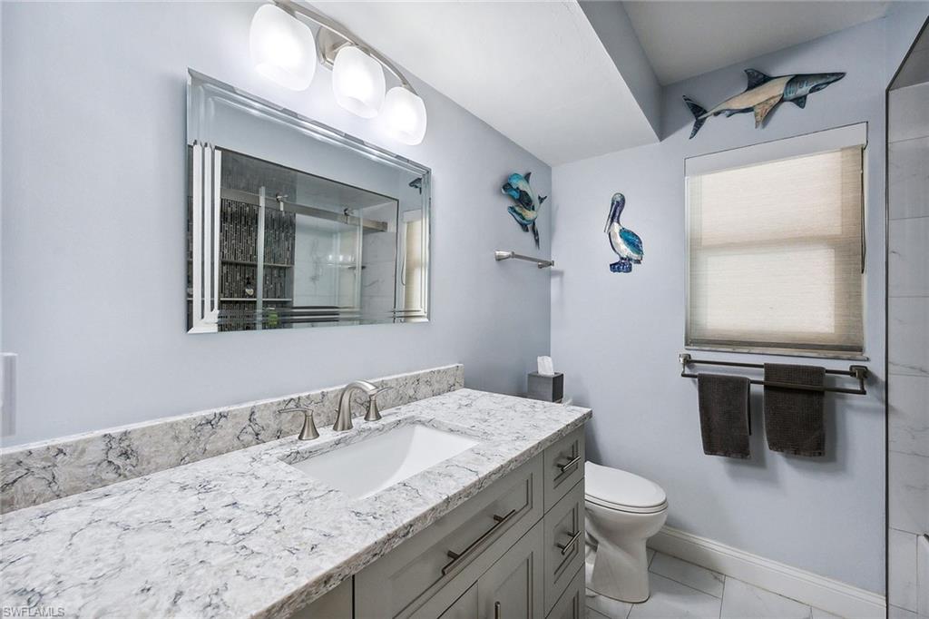 900 Hidden Harbour Drive Naples, FL 34109 - Photo 19 of 32 a bathroom with a granite countertop sink toilet and mirror