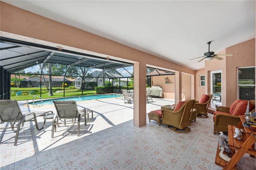 900 Hidden Harbour Drive Naples, FL 34109 - Photo 22 of 32 a view of a patio with table and chairs potted plants and floor to ceiling window