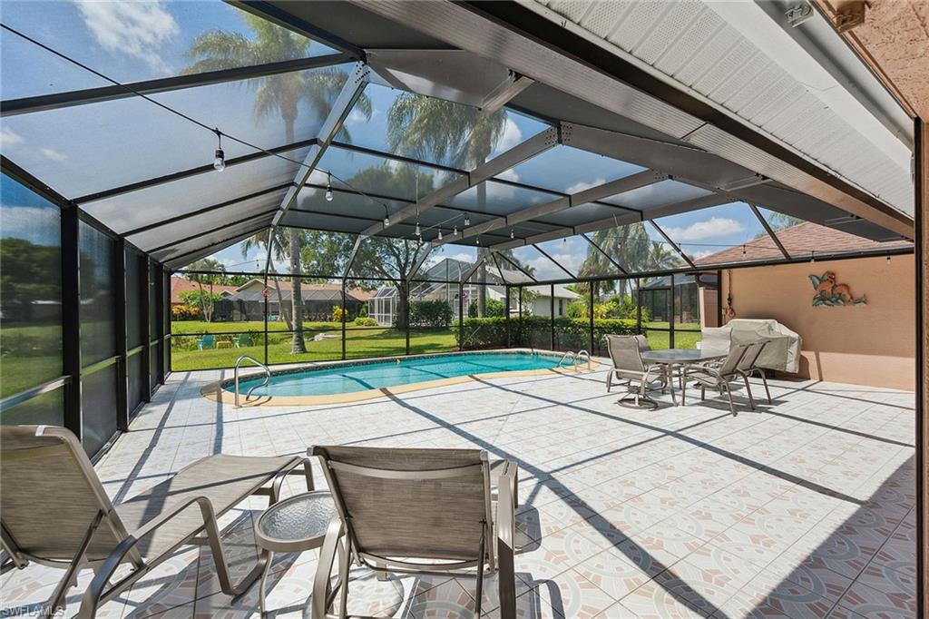 900 Hidden Harbour Drive Naples, FL 34109 - Photo 23 of 32 a view of backyard with a table and chairs under an umbrella