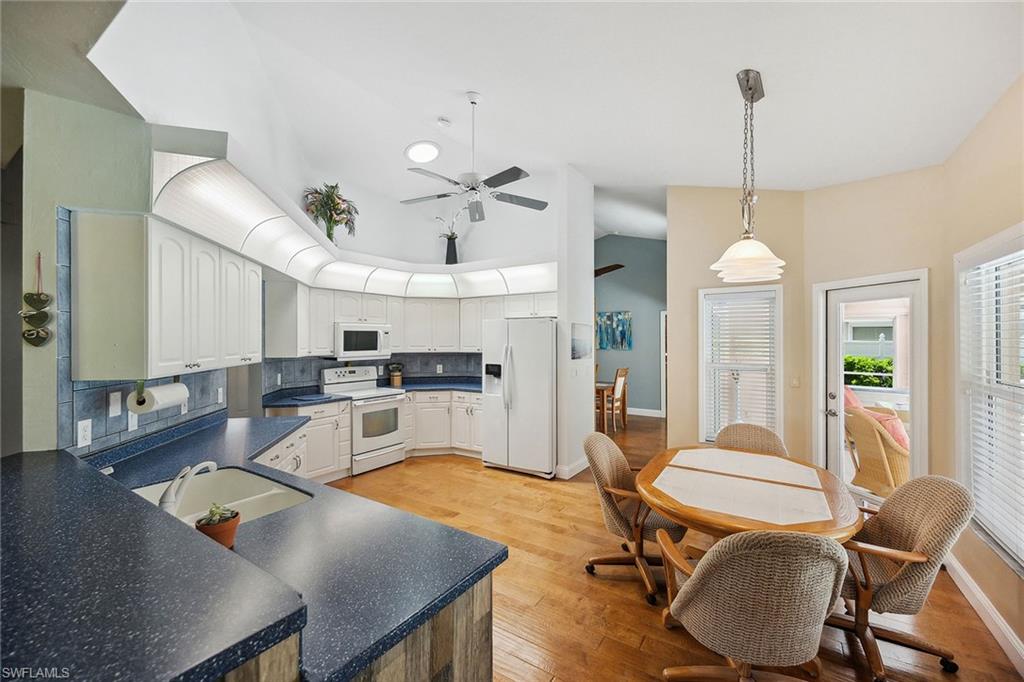 900 Hidden Harbour Drive Naples, FL 34109 - Photo 6 of 32 a living room with furniture a dining table and a chandelier