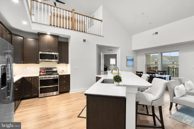 a kitchen with stainless steel appliances kitchen island granite countertop a sink and cabinets
