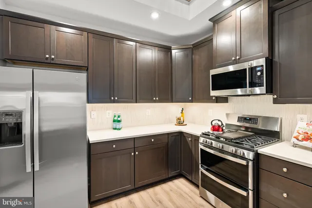 a kitchen with a sink stainless steel appliances and cabinets