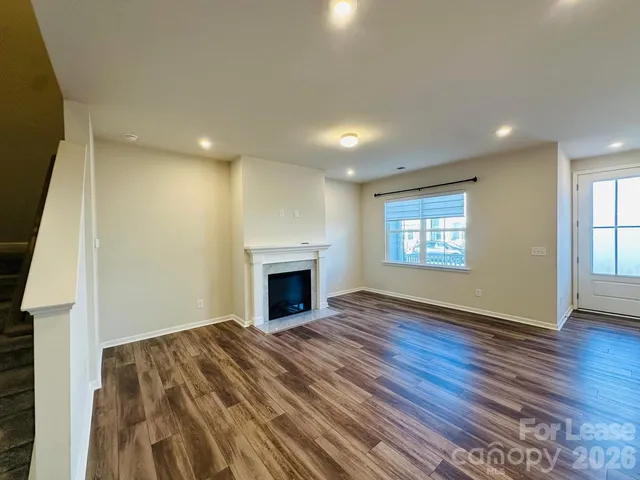a view of empty room with wooden floor and fireplace